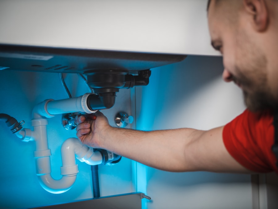 Técnico trabajando bajo el mueble del lavaplatos